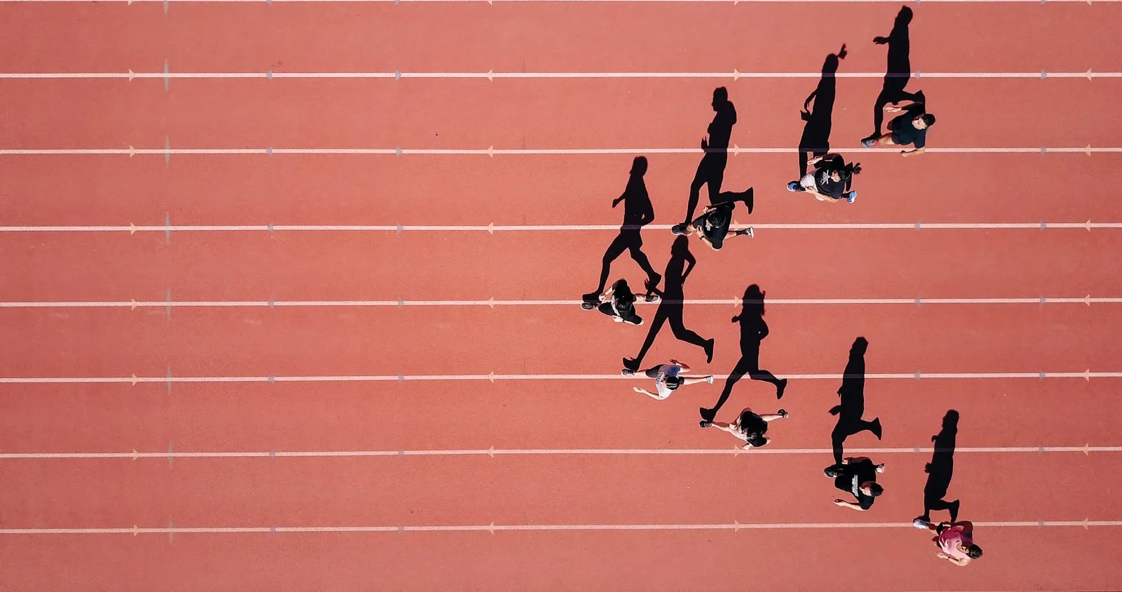 Coureurs en séance d'intervalles sur piste — la chaussure rapide sort uniquement pour les séances de qualité