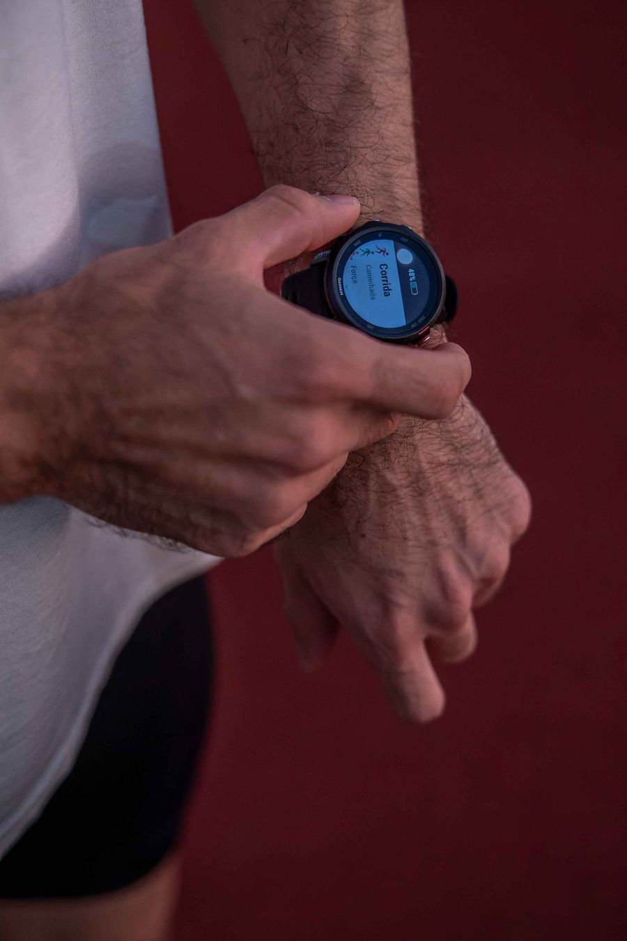 Coureur vérifiant ses données d'entraînement sur sa montre GPS — le suivi du volume hebdomadaire est la première étape de la gestion de charge