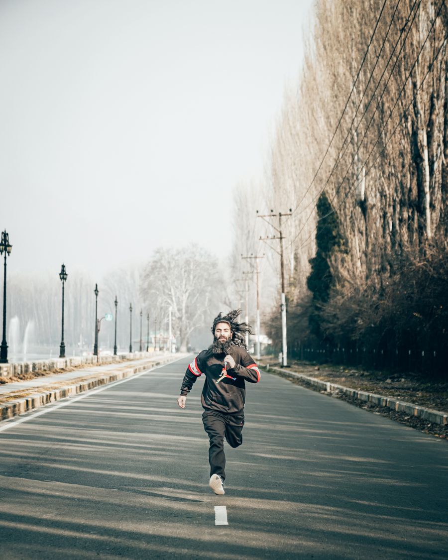 Coureur seul sur route en hiver, lumière froide — la régularité matinale se construit sur des séances qui ne coûtent rien à digérer